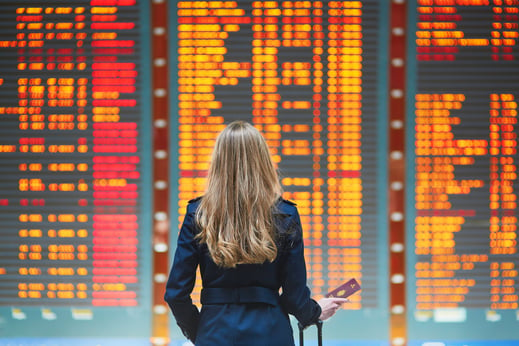Business traveler in front of airport flight display